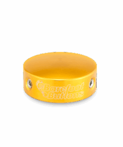 A yellow wristband with the words barefoot studios on it.
