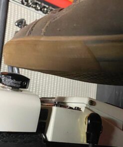 A shoe pressing a Barefoot Buttons V1 Standard Black footswitch topper installed on a guitar pedal.