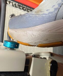 A Barefoot Buttons Standard Light Blue installed on a pedal, being pressed on and engaged by a shoe.