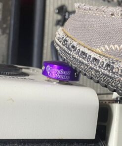 Close-up of a Barefoot Buttons V1 Standard Purple footswitch topper installed on a guitar pedal, pressed with a shoe.
