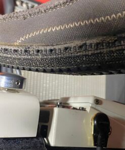 A shoe pressing a Barefoot Buttons V1 Standard Silver footswitch topper installed on a white guitar pedal.