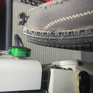 A shoe pressing a Barefoot Buttons V1 Standard Green footswitch topper installed on a guitar pedal.