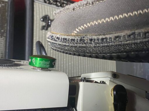 A shoe pressing a Barefoot Buttons V1 Standard Green footswitch topper installed on a guitar pedal.