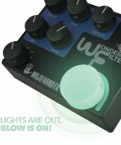A glowing green button on the top of a guitar pedal.