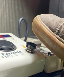 A V1 Mini Black Barefoot Buttton on an Eventide H9 pedal that is about to be stomped on by a shoe