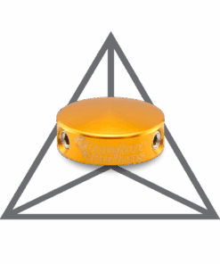 A yellow button sitting on top of a metal triangle.